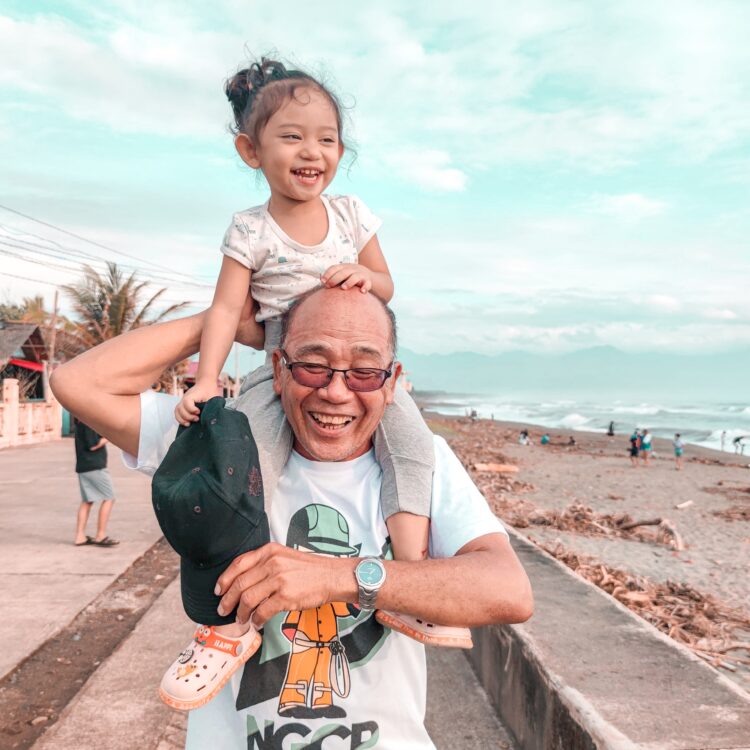 Smiling child at the beach with parent