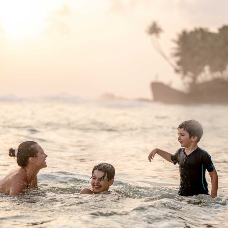 Mother and children smiling at the beach