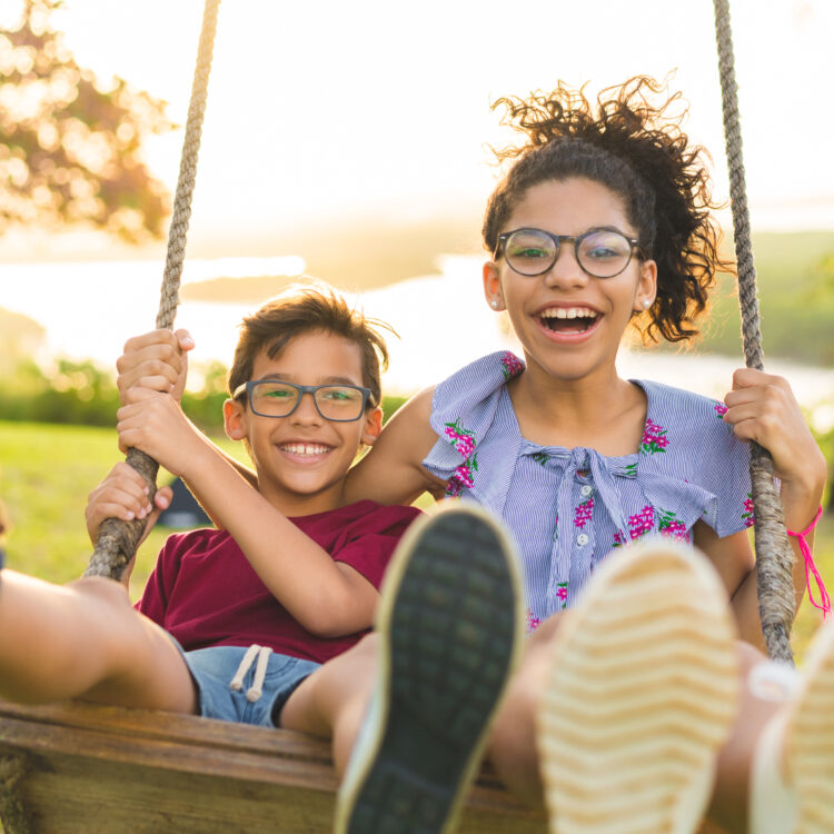 Brother and Sister showing off her smile on a swing in Tracy, CA