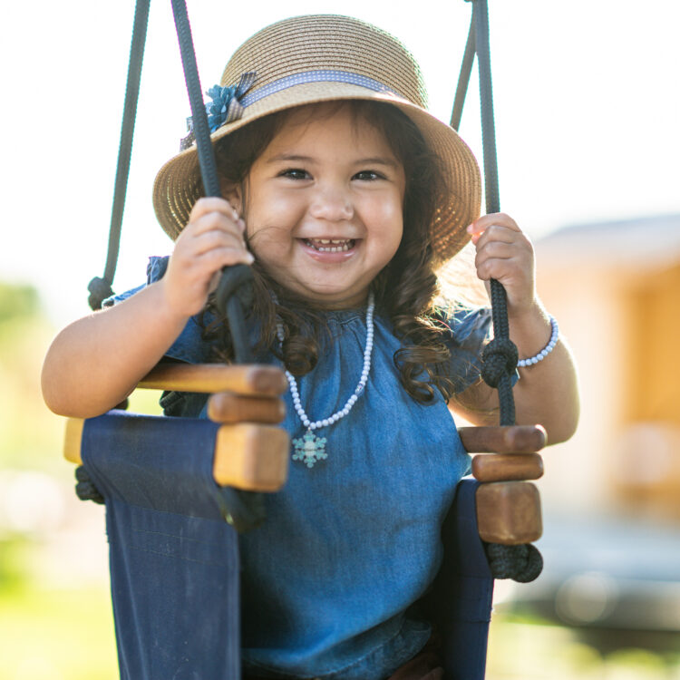 Child smiling on a swing in Tracy, CA